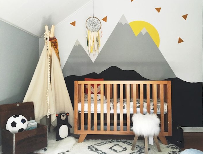 idée déco chambre bébé sous pente lit bois enfant tipi enfant toile blanche tapis cocooning peinture murale motif montagne soleil