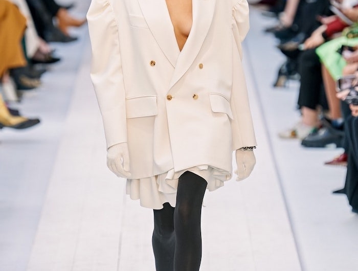 kaia gerberdans un manteau surdimensionne blanc et bottes longues jusqu aux genoux