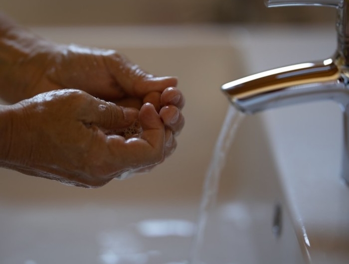 lave des mains dans un lavabo ceramique prevention de virus