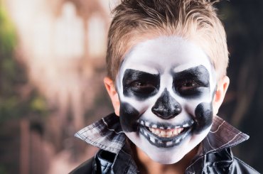 45443232 scary little boy smiling wearing skull makeup for halloween