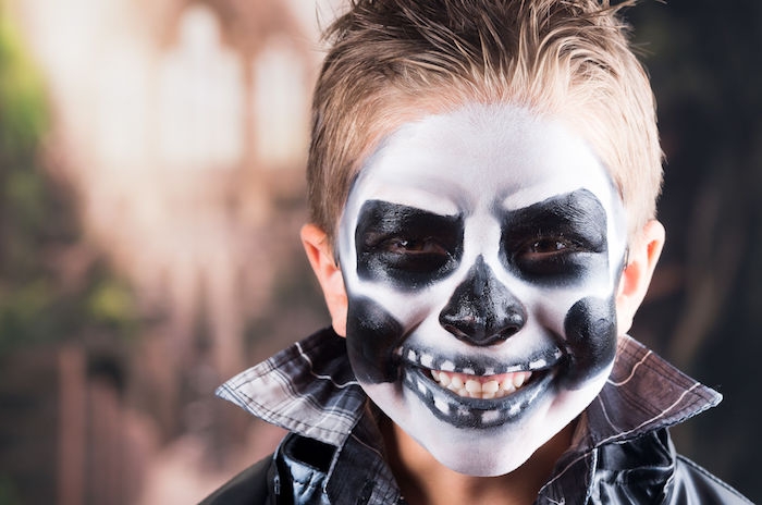 45443232 scary little boy smiling wearing skull makeup for halloween