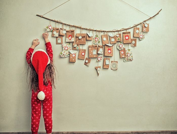 mini sachets cadeau remplis de petits cadeaux exemple de calendrier de l avent enfant sur branche accorché au mur