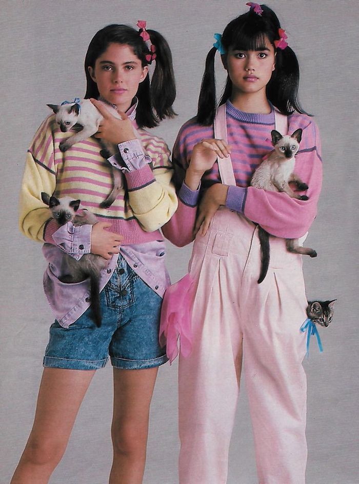 mode année 80 deux filles avec une salopette et des shorts en jean trois chats et des cheveux en queues