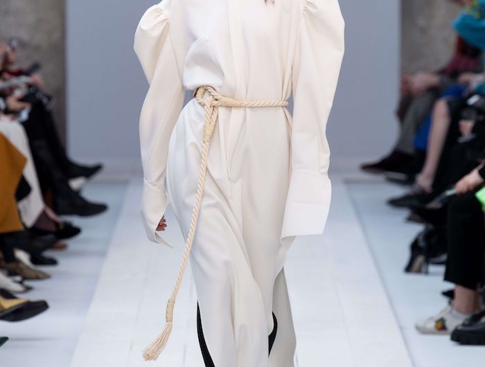 mode automne hiver 2020 une robe chemisier aux manches logues blanche et surdimensionnee avec des bottes noires