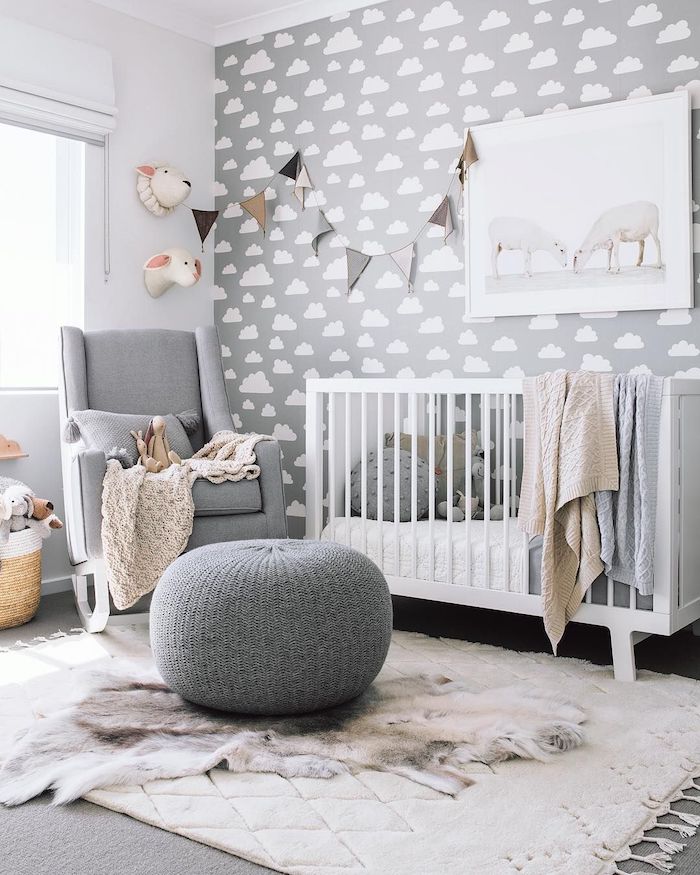 mur décoré de papier peint gris à nuages fauteuil gris lit bébé blanc tapis moelleux pouf cosy idée déco chambre bébé garçon