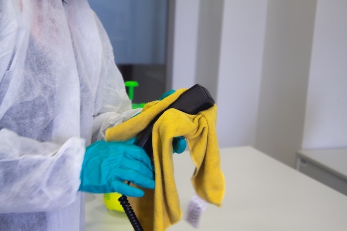 nettoyage de la maison avec un torchon et un costume chirurgique