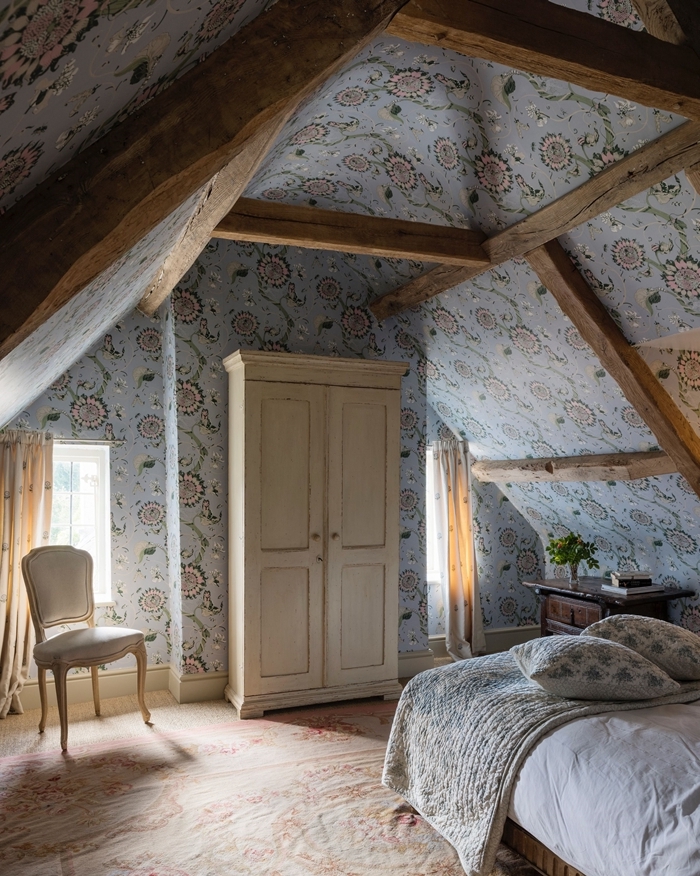 papier peint bleu motifs floraux poutres apparentes bois brut aménagement sous comble chambre adultes garde robe