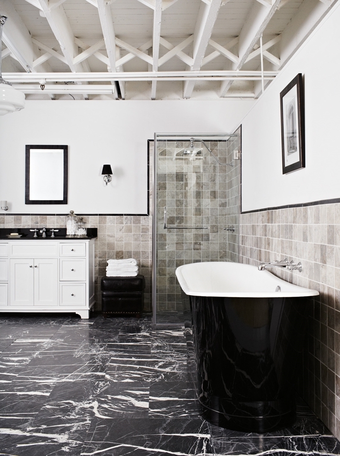 plafond poutres bois blanc apparentes salle de bain art déco cadre miroir noir baignoire noire dalles marbre noir