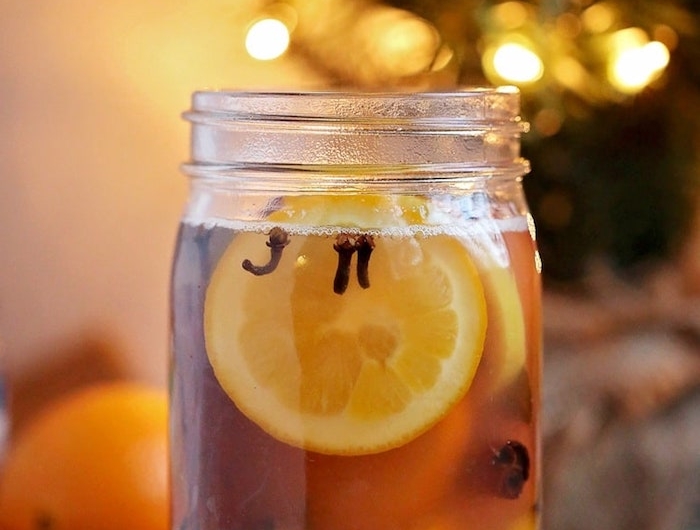 pot pourro dans pot en verre avec des tranches d orange et de citron et des épices de noel variés en eau