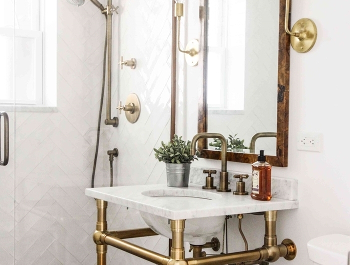 robinet métal évier sur pieds dorés salle de bain vintage revêtement mur carrelage blanc motifs géométriques miroir bois