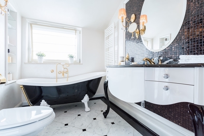 salle de bain retro chic décoration intérieure style antan luxe baignoire noir brillant accents laiton carrelage marbre