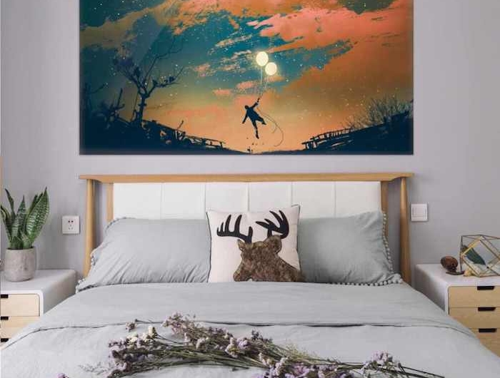 sticker mural dessin fantastique au dessus du lit dans la chambre a coucher des drapes gris sur le lit