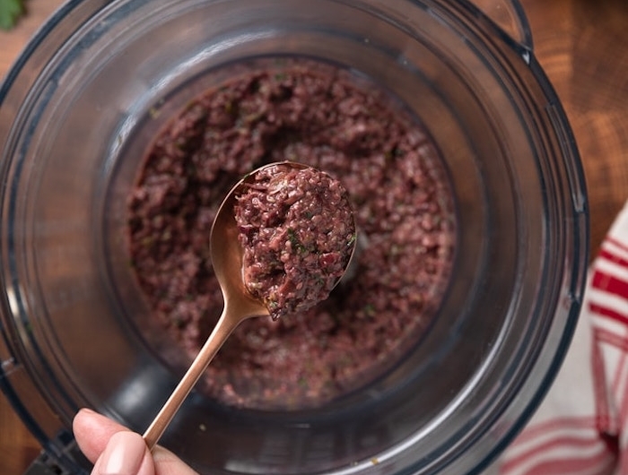 tartine salee a la base d olives mixture dans un robot de cuisine avec une cuillere bronzee