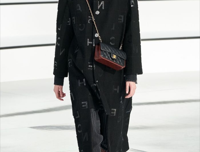 tenue casual chic manteau surdimensionne noir avec des bottes en cuir et un sac en badelier
