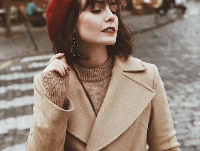 tenue femme hiver béret marron coupe avec frange boucles d oreilles or pull over robe beige manteau ceinture boutons