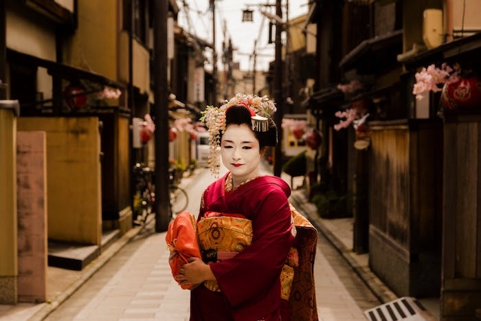 une femme dans un costume traditionnel japponnqais dans la rue esthetique multicolre et vibrante