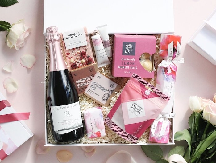 anniversaire en confinnement idee de cadeau une boite avec de champagne produits de beaute et un bouquet de roses