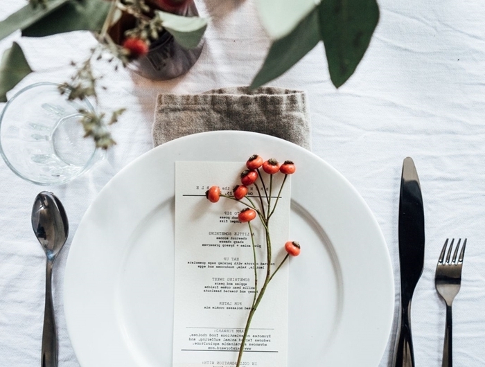 assiette blanche couvercles argent decoration table de noel rouge et blanc verres nappe banche verdure table bougie