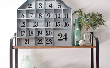 calendrier de l avent ado garcon avec une maison en bois decorative pose sur une etagere