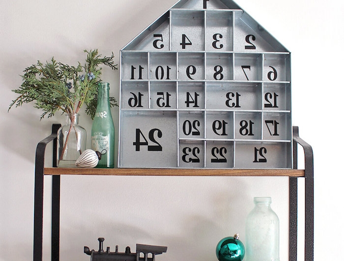 calendrier de l avent ado garcon avec une maison en bois decorative pose sur une etagere