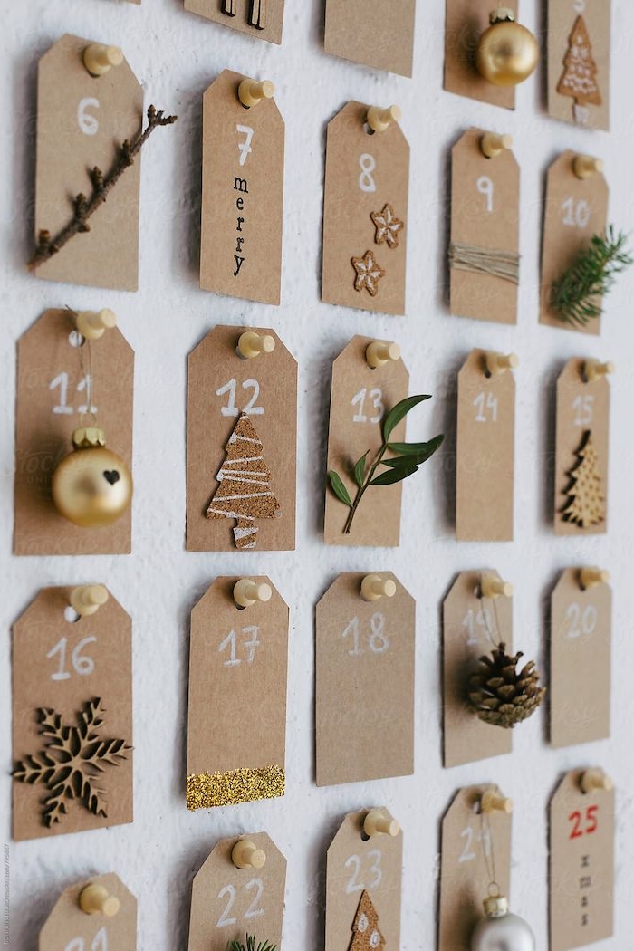 calendrier de l avent original avec des petits notes numerotes decores des petits branches et jouettes papier brun epingle au mur