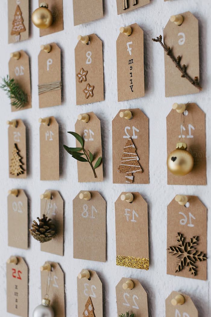 calendrier de l avent original avec des petits notes numerotes decores des petits branches et jouettes papier brun epingle au mur