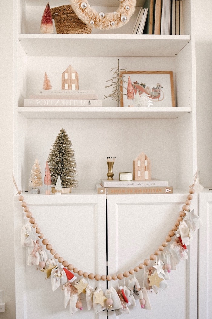 calendrier de l avent original avec un guirlande des petites figurines devant une etagere avec des souvenirs