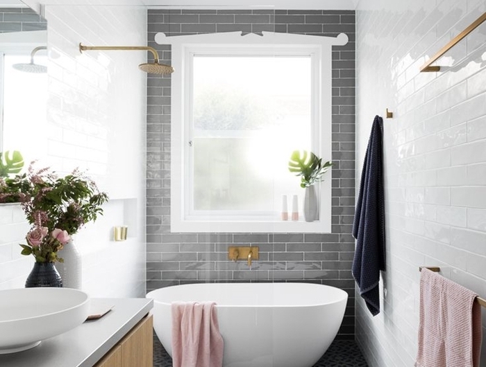 carrelage métro gris séche linge serviette de bain rose pastel salle de bain avec baignoire meuble évier bois