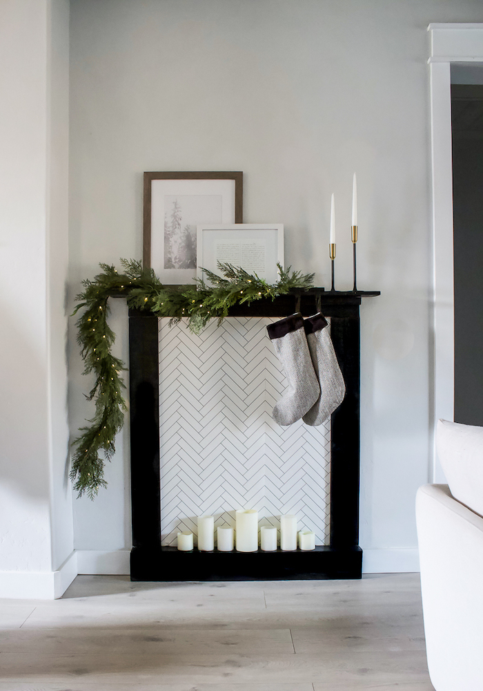 cheminée en carton de noel fausse pleine de bousies en style minimaliste avec deux chausettes en noir et blanc