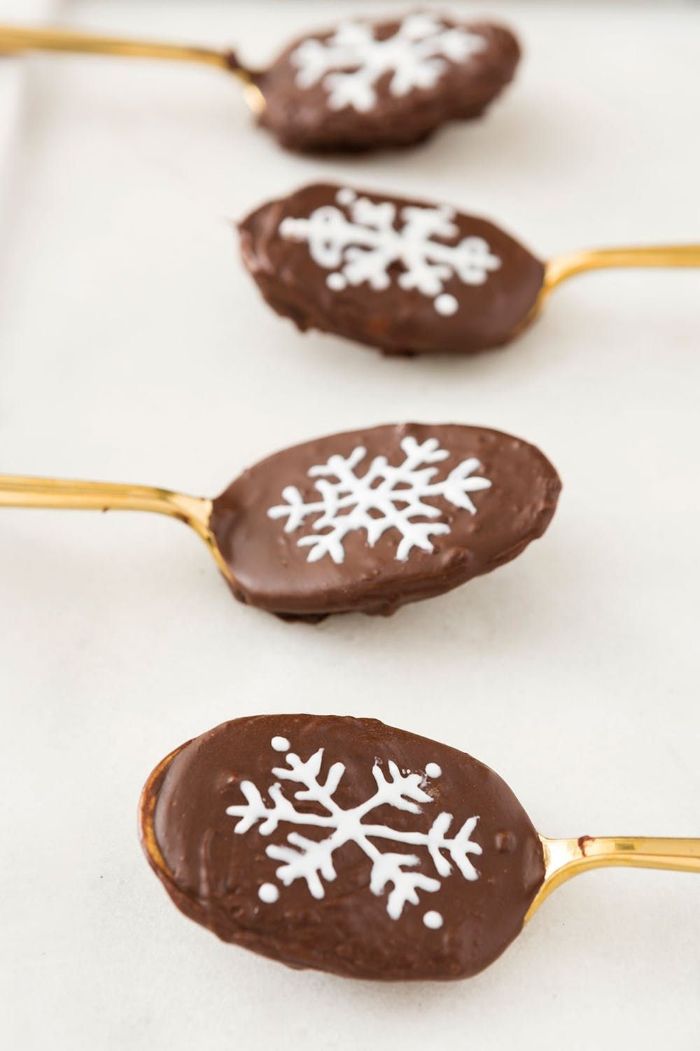 cuillères chocolatées couleur or avec chocolat au lait et dessin flocon de neige au chocolat blanc faires des chocolats maison