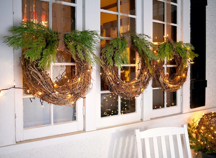 decoration de noel exterieur pas cher avec des courrones faits des vignes et des branches de sapin suspendus a la fenetre