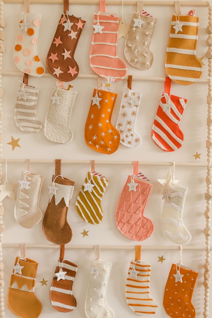 des chausettes multicolores en rayes et etoiles epingles sur un panneau calendirer de l avent fait maison