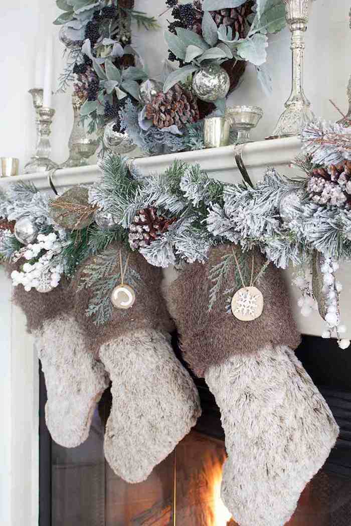 des chausettes tricotees suspendus de la cheminée avec des guirlandes et des cones de pin saupodres de fausse neige