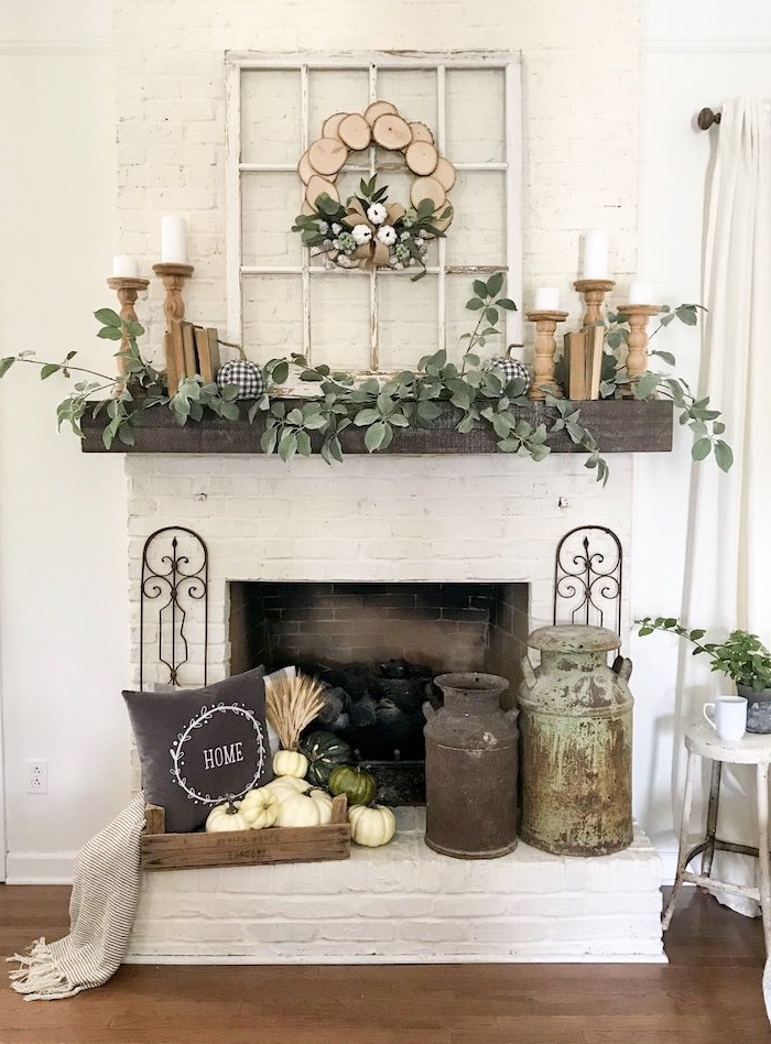 décoration de la cheminée avec de la verdure des vase vintages et une couronne en bois