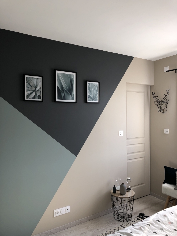 déco chambre moderne mur bicolore motifs géométriques peinture mur triangle table café bois et métal cadres photos noirs