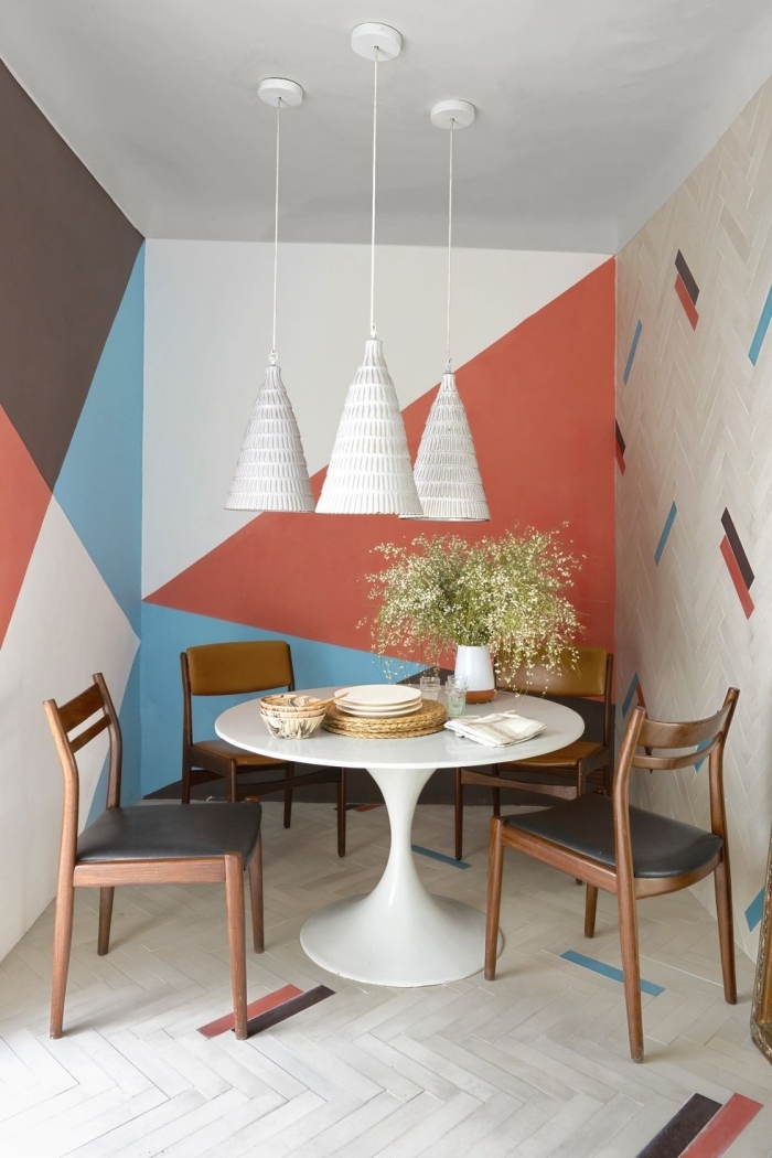 décoration salle à manger petite table ronde blanche chaise bois peinture triangle couleur orange lampe suspendue