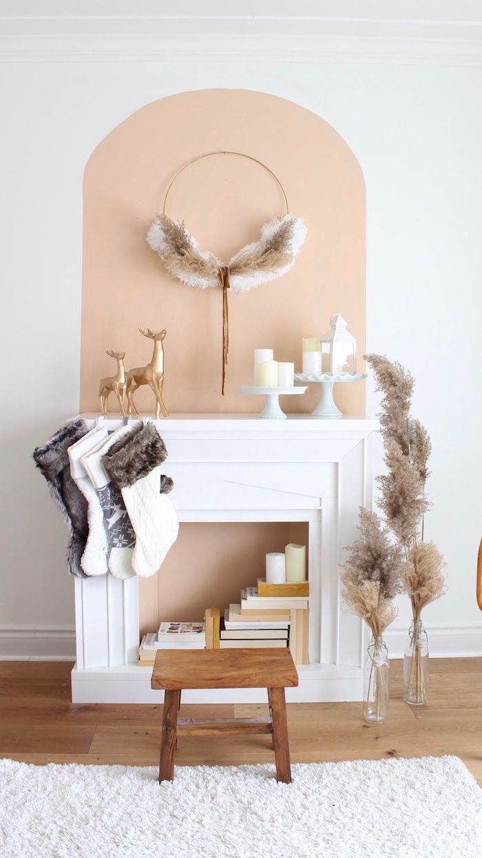 fausse cheminée noel pleine de livres avec des chaussettes et des petits cerfs dorees decoration minimaliste