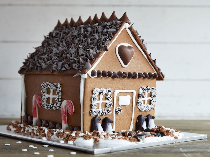 maison en pain d epices decoree avec des elements en chocolat et des batons gelees