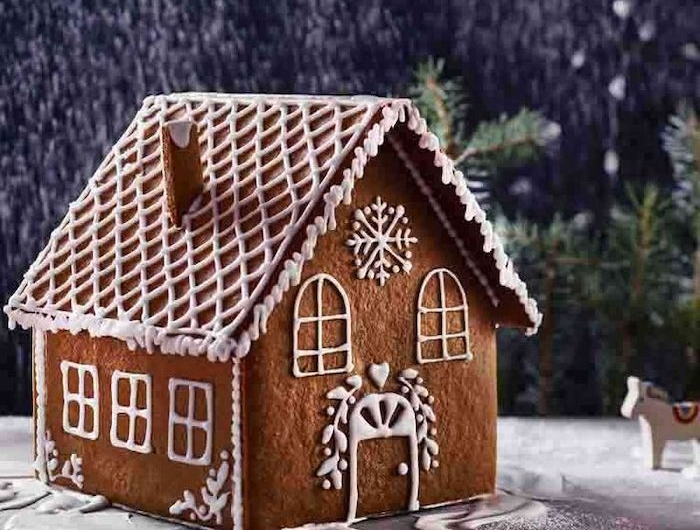 maison pain d epice en forme traditionnellle decoree avec de glacage royal et des ornaments hivernales