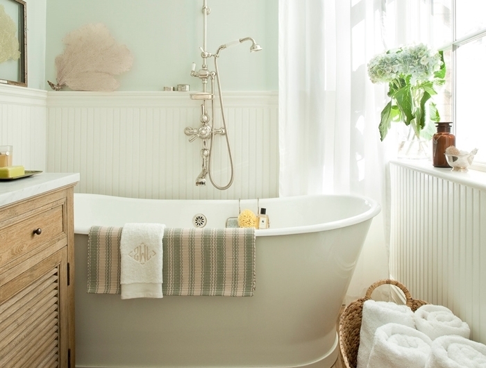 modele salle de bain rétro style peinture murale pastel vert menthe baignoire blanche panier tressé serviette de bain