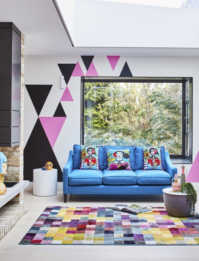 peinture géométrique salon tapis motifs carreaux multicolore canapé bleu table café béton formes triangulaires peinture rose