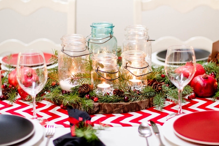 rondelle bois table de noel traditionnelle nappe blanc et rouge assiette ronde pots verre fruits verdure bougies