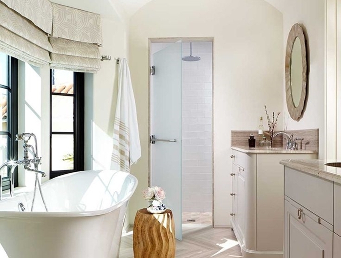 salle de bain avec baignoire autportante luminaire laiton meubles bois revêtement sol aspect bois clair