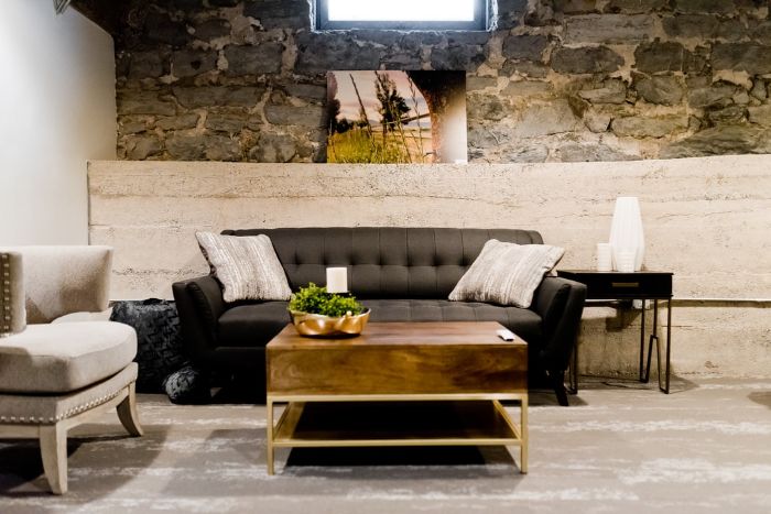 salle de sejour style moderne murs en pierres canapé en gris anthracite table basse