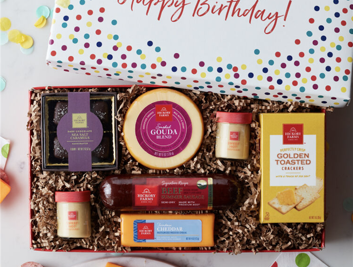 une boite avec des petits cadeaux delicieux de frommage de saucisson et des chocoats idee d envoyer a un ami pour son anniversaire
