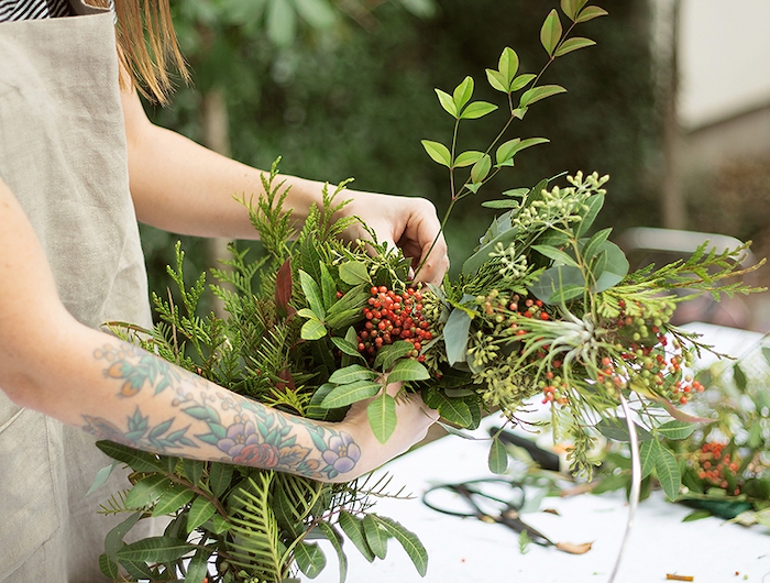 une femme qui fait une couronne a l aide des plantes vertes et un cercle en metal deco noel pas cher