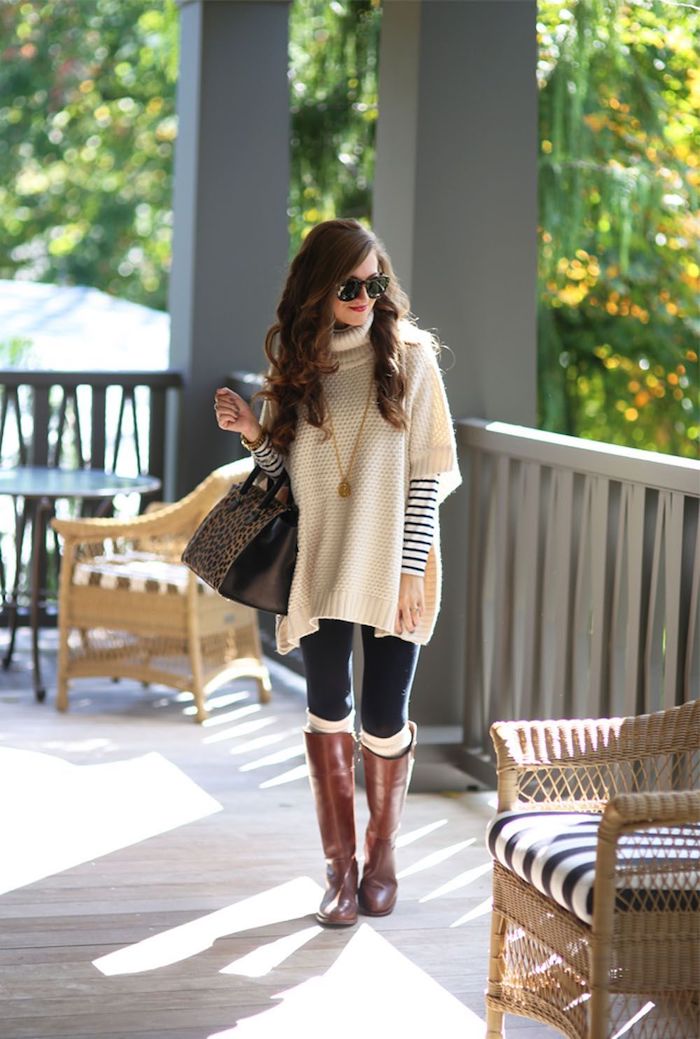 une femme vetue en poncho au col avec des bottes hautes en marron et cuir un look parfait pour les mois froids