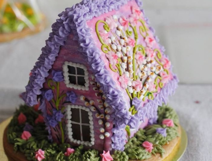 une maison en pain d épices decorée de fleurs en creme violet et rose idee de dessert de noel