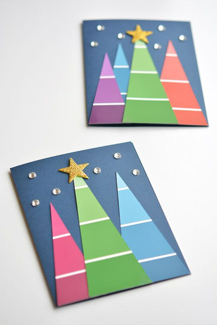 carte de noel a fabriquer avec des sapins de papier coloré avec décoration d étoile et strass sur papier bleu