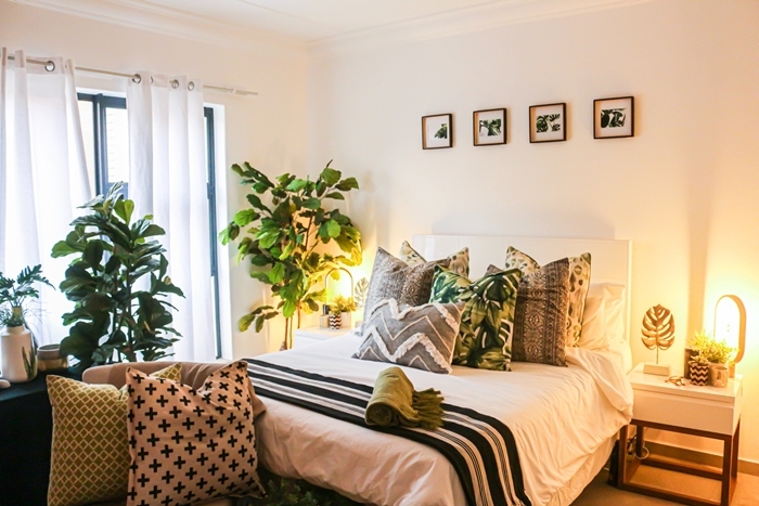chambre parentale cosy plantes vertes chambre adultes mur cadres photos blanc et noir coussins décoratifs